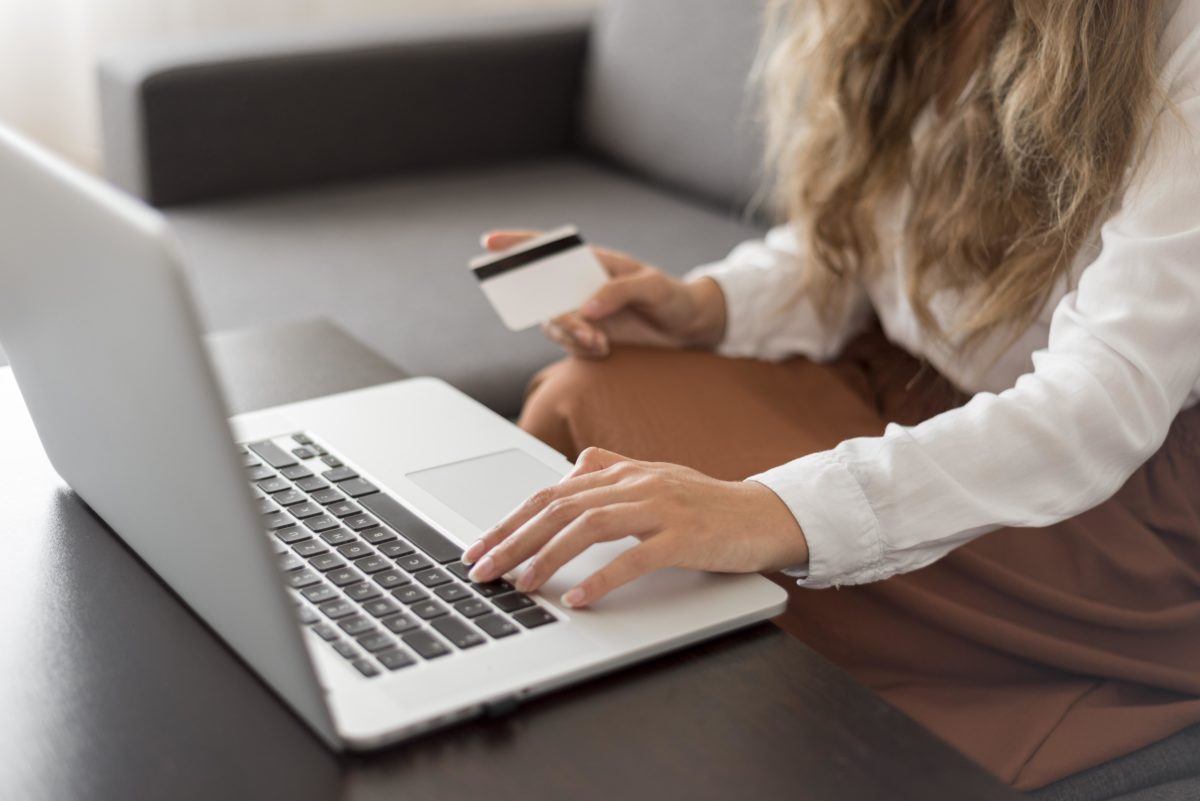 Image montrant une femme devant son ordinateur avec sa carte bancaire.